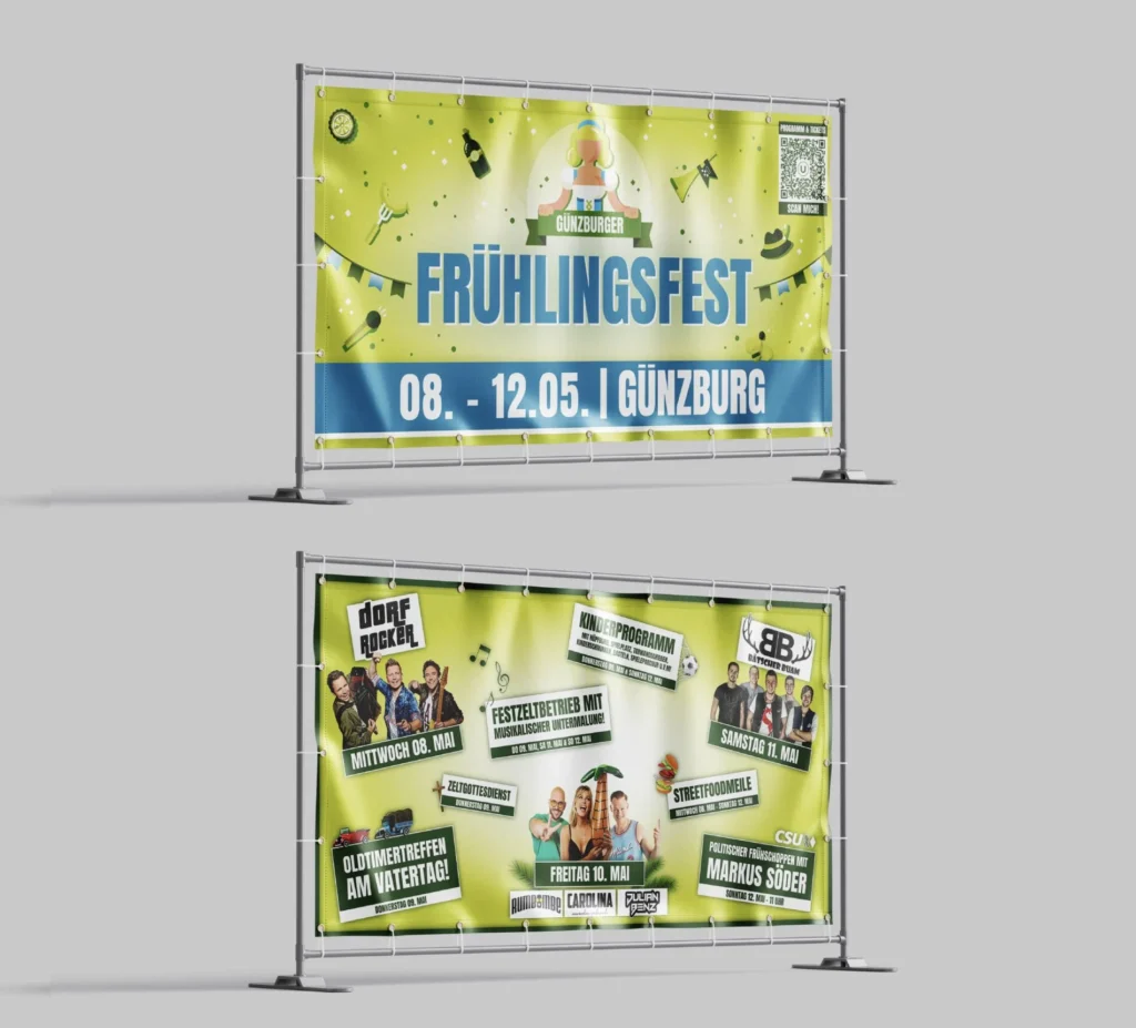Zwei Bauzaunbanner zeigen gelb-grüne Werbung für das Frühlingsfest Günzburg; eines enthält Termin und Titel, das andere Programmmotive.